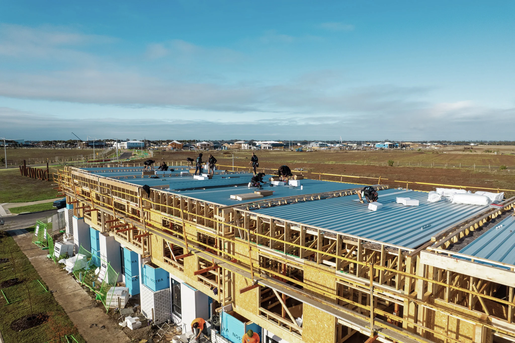 Aerial view of a multi-lot townhouse development during framing and roofing