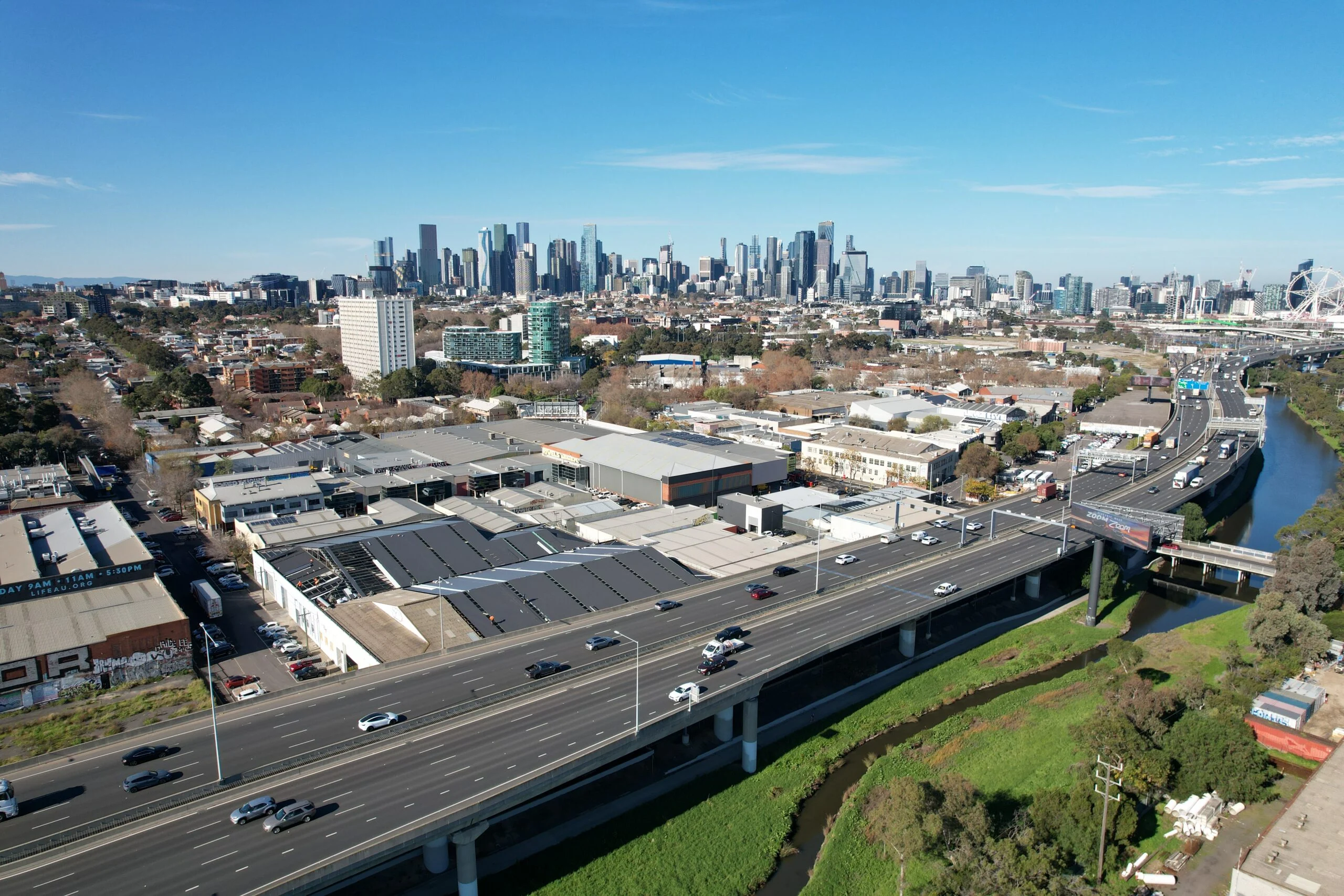 Wide aerial view of an inner Melbourne area with the city skyline behind